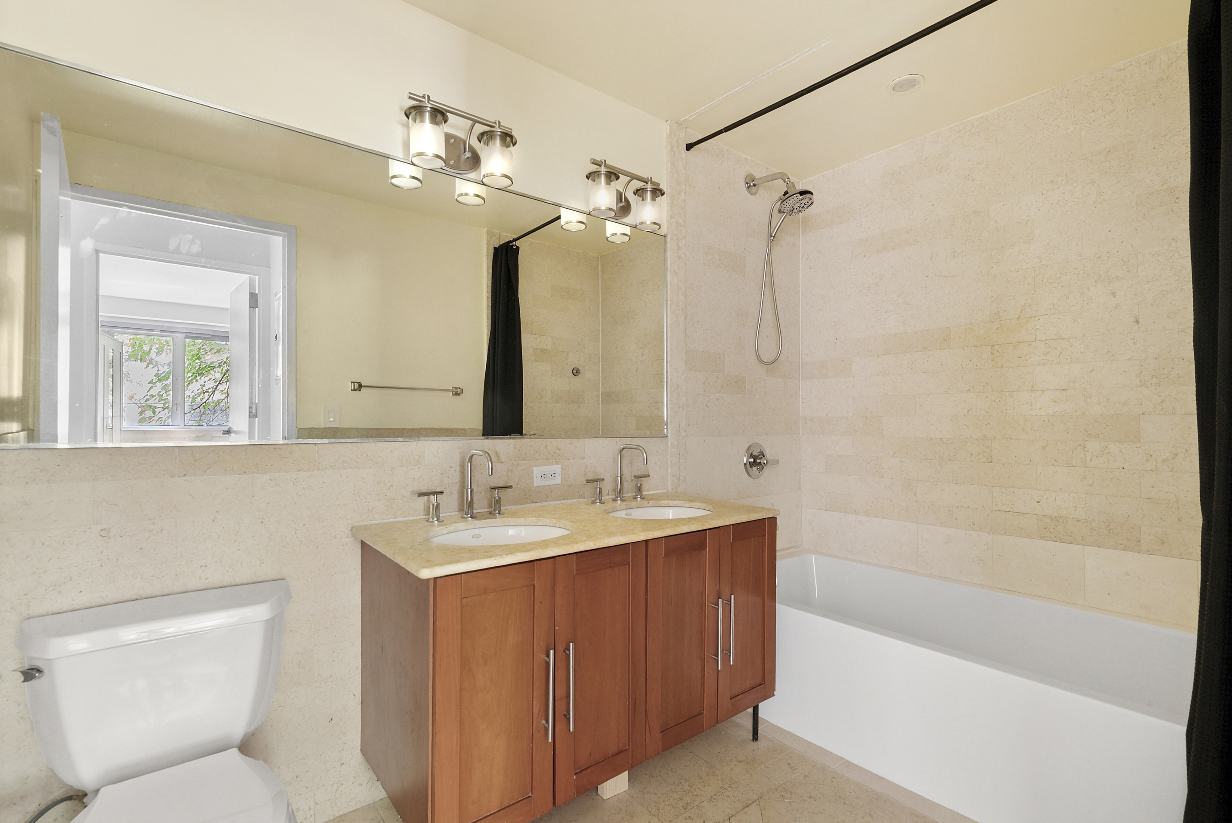 450 East 117th Street, Unit 1A Manhattan, NY 10035 - Photo 5 of 10 a bathroom with a sink a toilet a mirror a bathtub and shower
