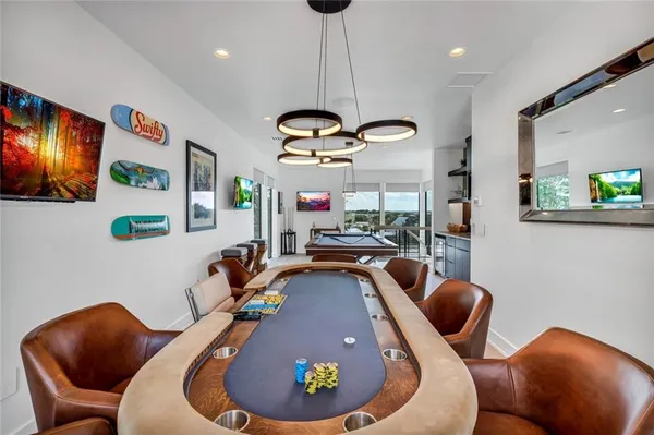 a living room with furniture pool table and stainless steel appliances