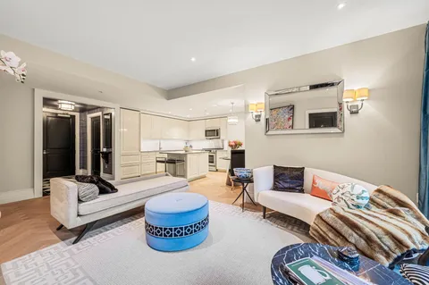 a living room with furniture and view of kitchen