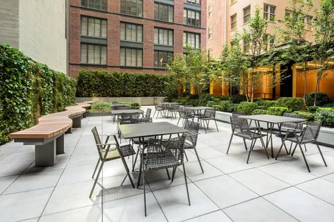 a view of a patio with a table and chairs and potted plants