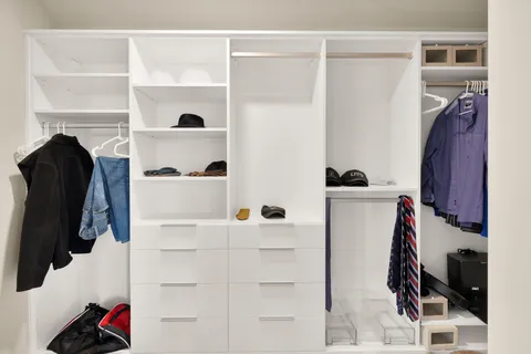 a bedroom with a bed and large windows