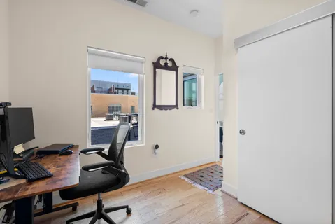 a view of a workspace with furniture and wooden floor