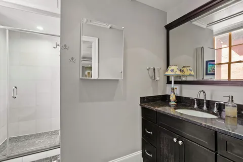 a bathroom with a granite countertop sink and a mirror