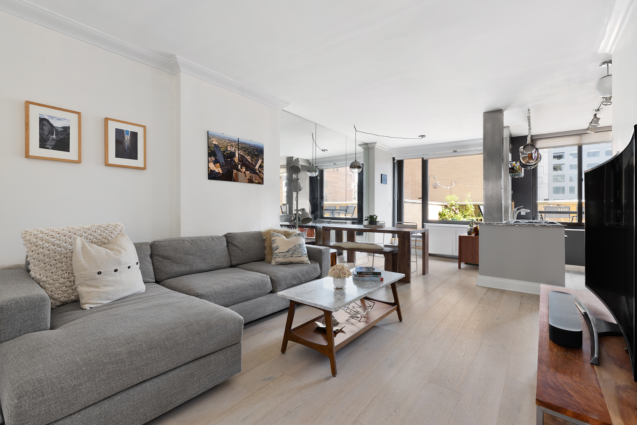 111 East 30th Street, Unit 16C Manhattan, NY 10016 - Photo 3 of 13 a living room with furniture and a dining table with kitchen view