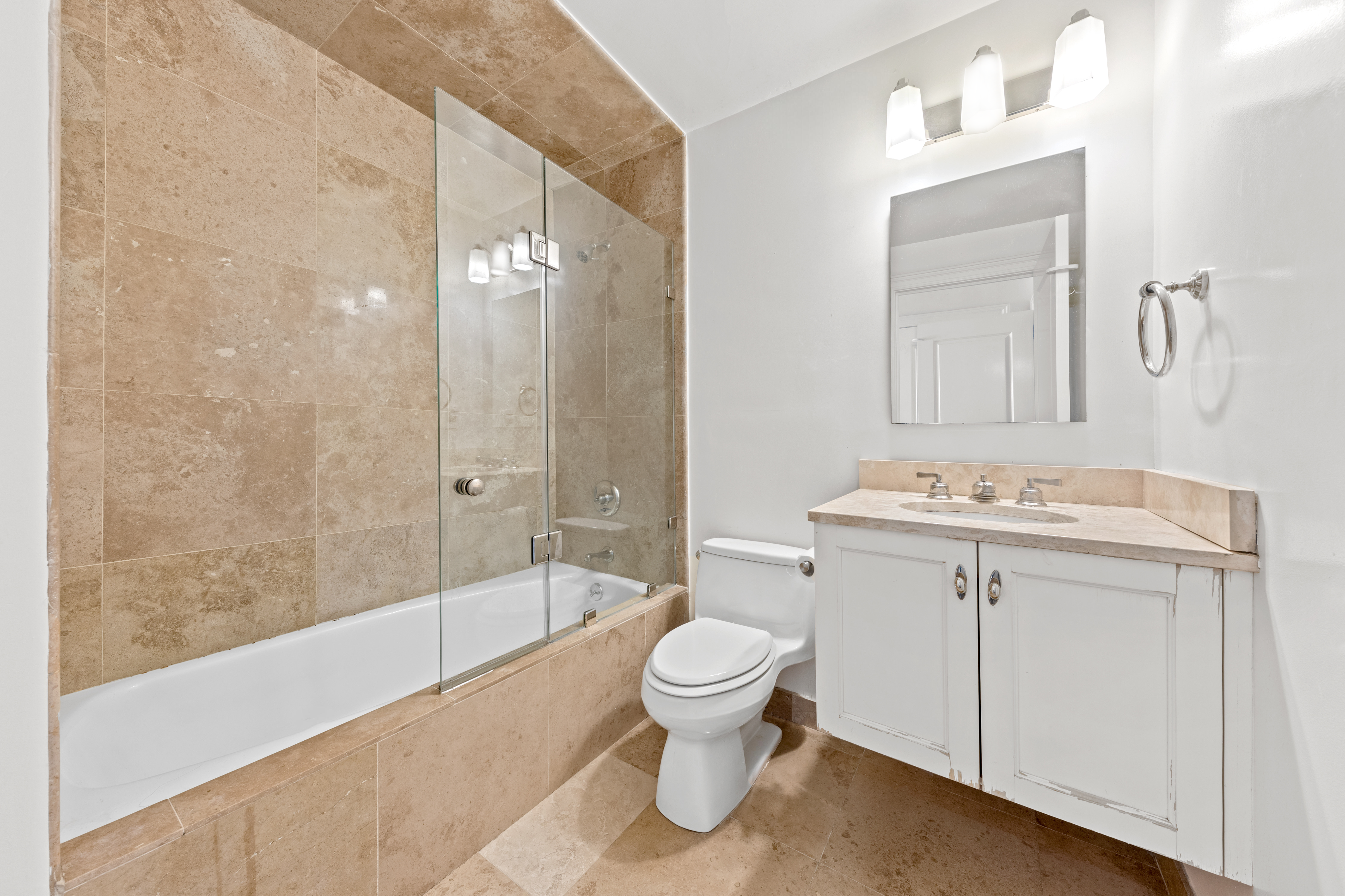 40 East 94th Street, Unit 21F Manhattan, NY 10128 - Photo 6 of 8 a bathroom with a sink a toilet and a bathtub