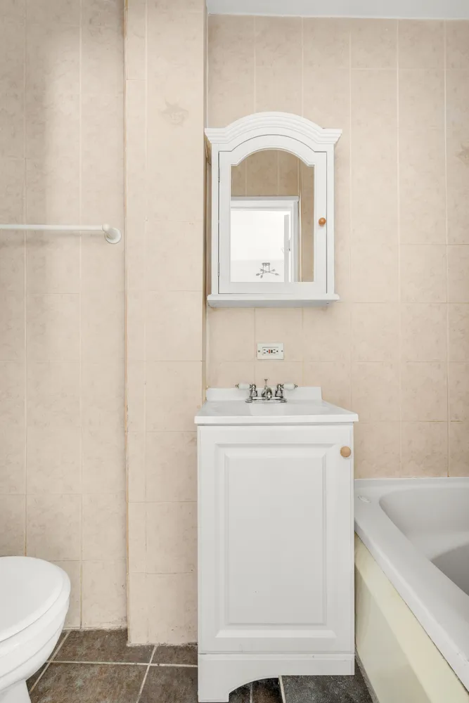 a bathroom with a sink a toilet and a mirror