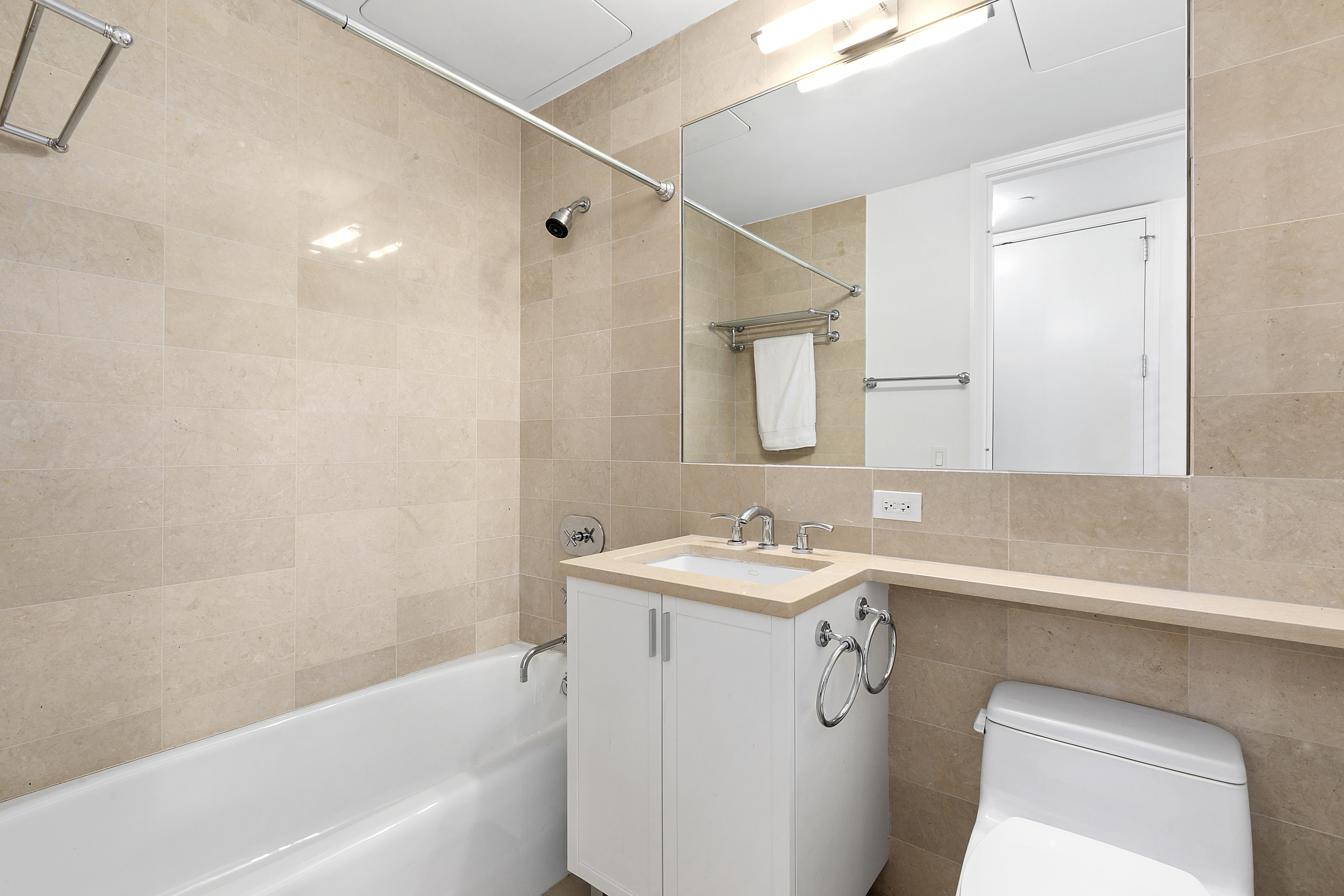 25 Columbus Circle, Unit 65E Manhattan, NY 10019 - Photo 9 of 11 a bathroom with a sink a toilet and a bathtub