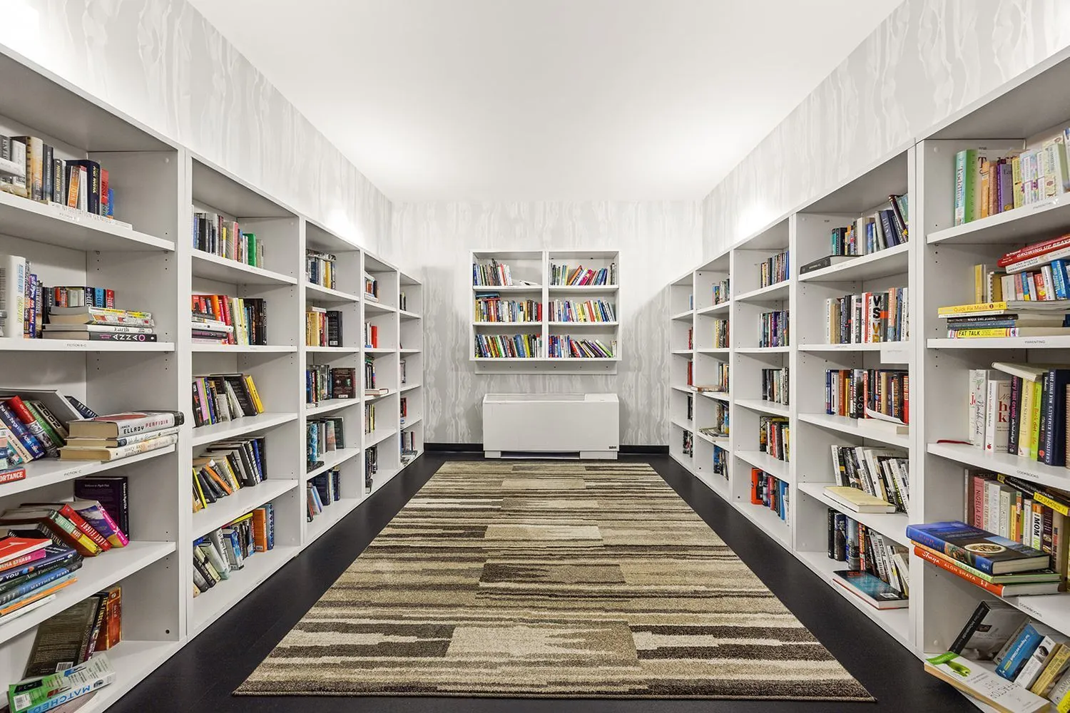 a view of room with windows book shelves