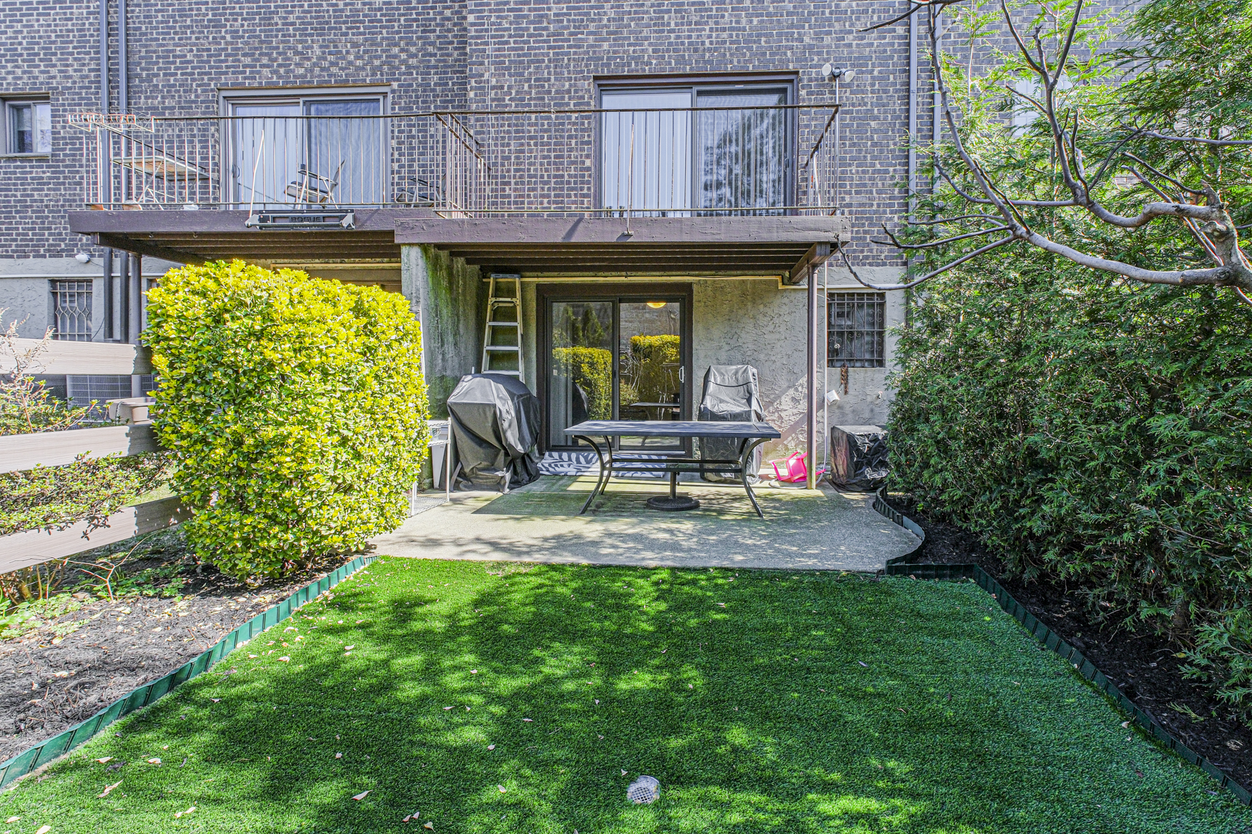 97 Dogwood Lane Staten Island, NY 10305 - Photo 20 of 22 a view of a patio with table and chairs potted plants and large tree