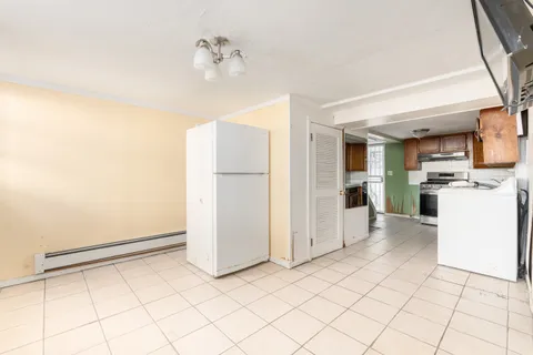 a kitchen with a refrigerator and white cabinets