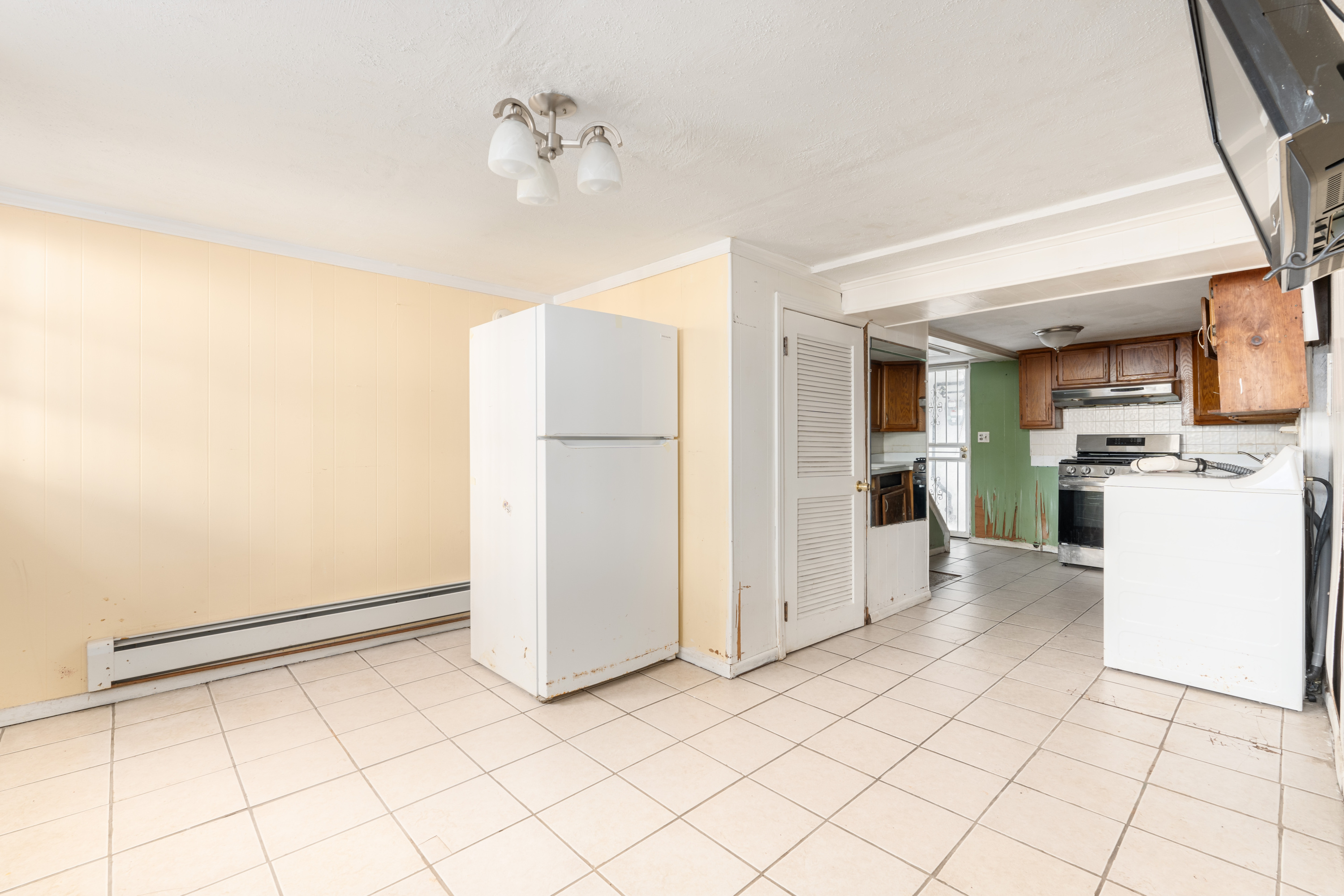 143-17 101st Avenue Queens, NY 11435 - Photo 3 of 10 a kitchen with a refrigerator and white cabinets