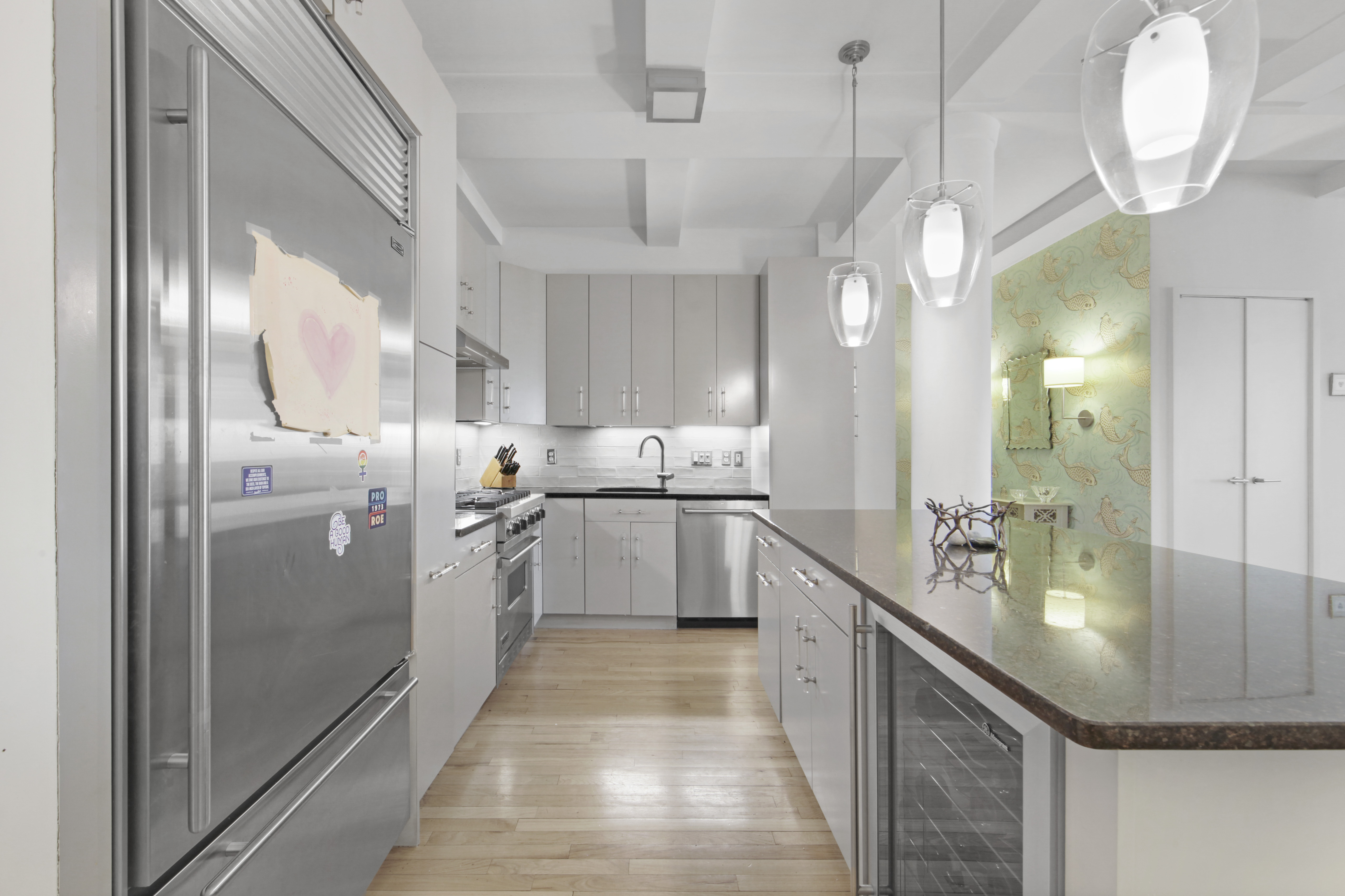 18 East 12th Street, Unit 7BC Manhattan, NY 10003 - Photo 6 of 26 a kitchen with stainless steel appliances granite countertop a refrigerator a oven a sink and a chandelier