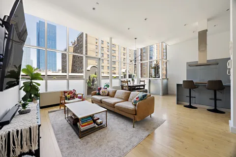 a living room with furniture gym equipment and a floor to ceiling window