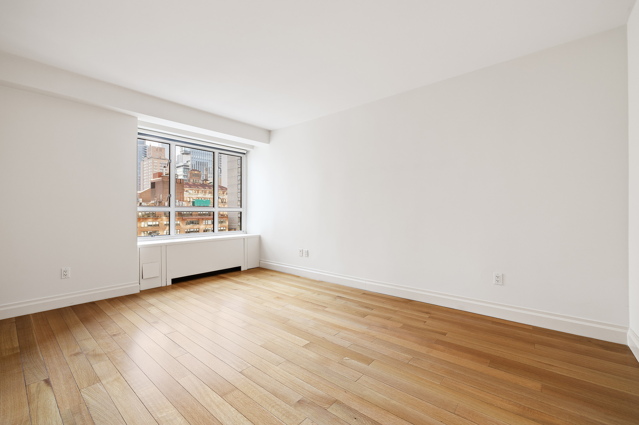 200 East 66th Street, Unit D1203 Manhattan, NY 10065 - Photo 12 of 24 an empty room with wooden floor and windows