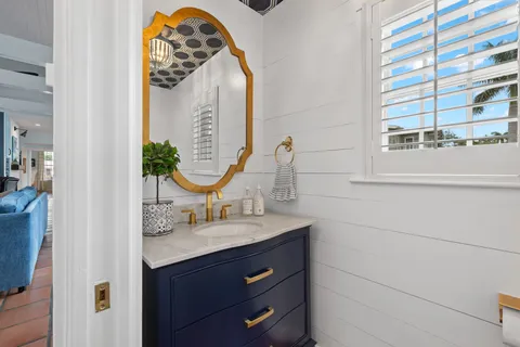 a kitchen with granite countertop lots of white furniture a sink a window and dining table