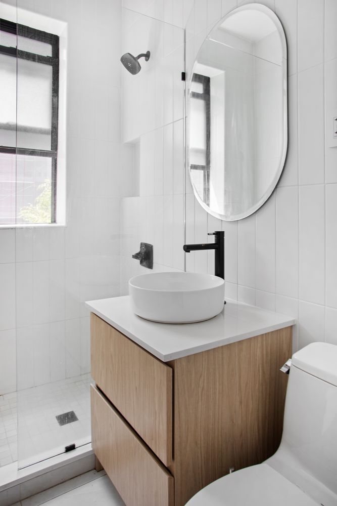 129 West 89th Street, Unit 45 Manhattan, NY 10024 - Photo 4 of 6 a bathroom with a sink toilet a mirror and shower