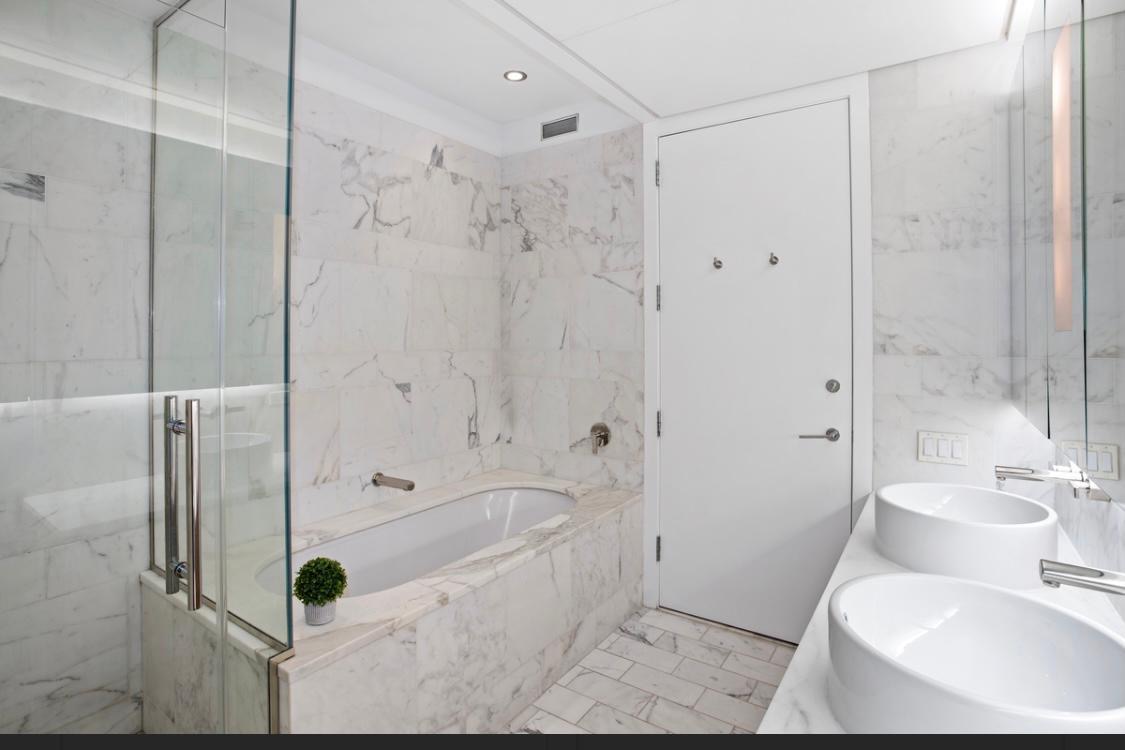 18 West 48th Street, Unit 3B Manhattan, NY 10036 - Photo 5 of 8 a bathroom with a tub and shower