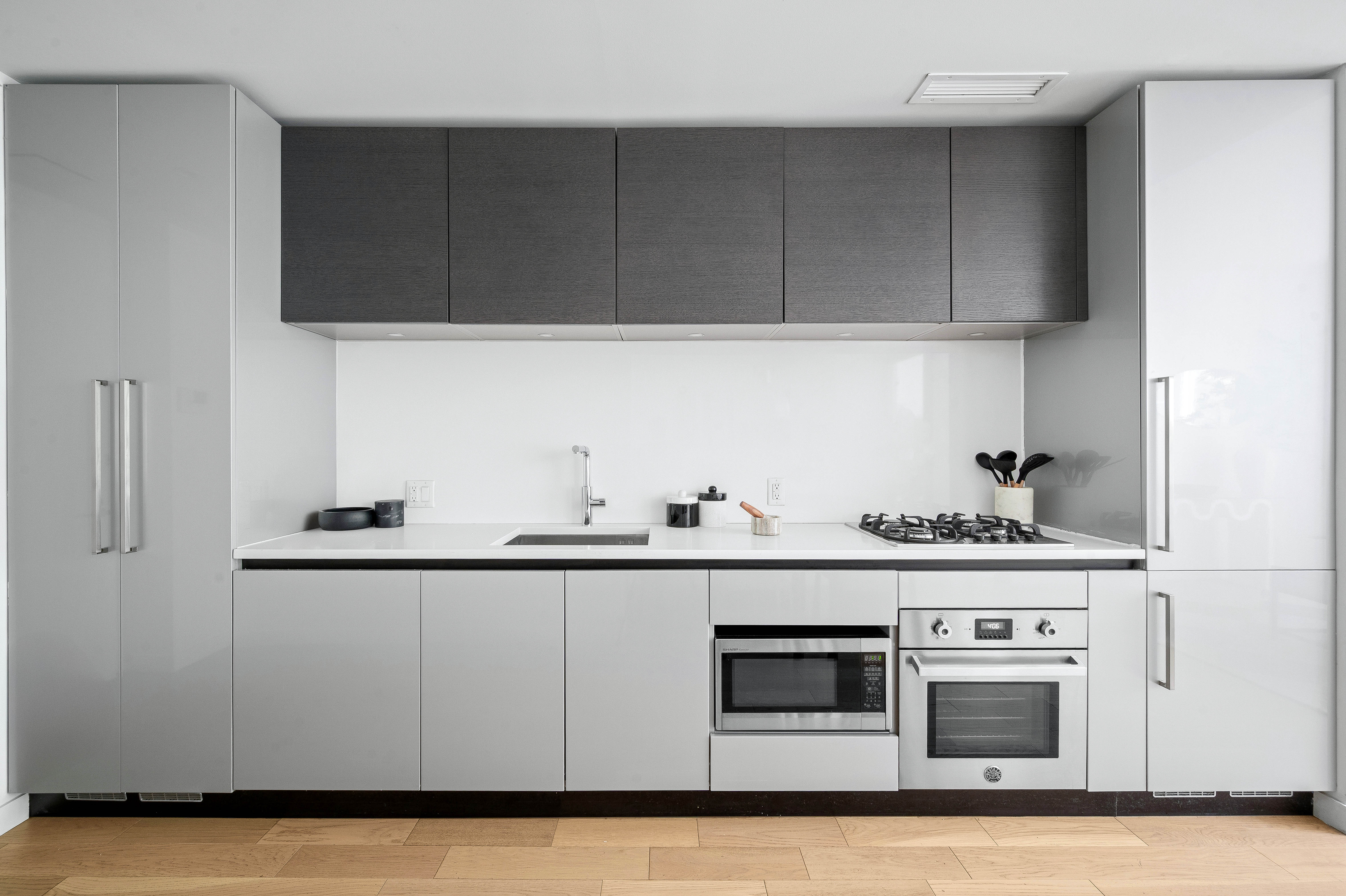 540 West 49th Street, Unit 306S Manhattan, NY 10019 - Photo 5 of 13 a kitchen with granite countertop white cabinets and stainless steel appliances