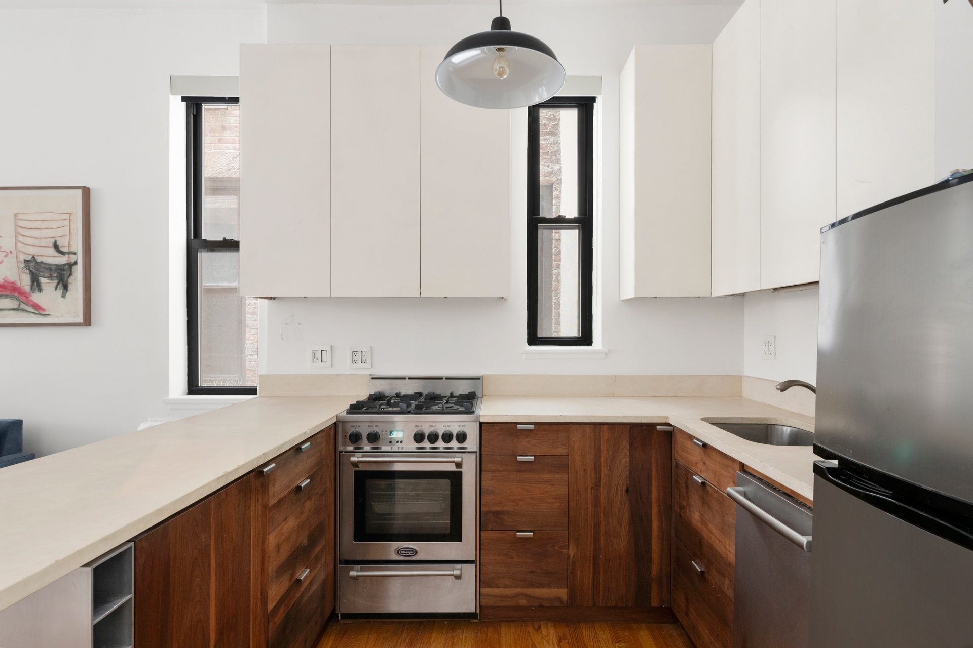 360 West 21st Street, Unit 2L Manhattan, NY 10011 - Photo 5 of 11 a kitchen with stainless steel appliances a sink a stove and a refrigerator