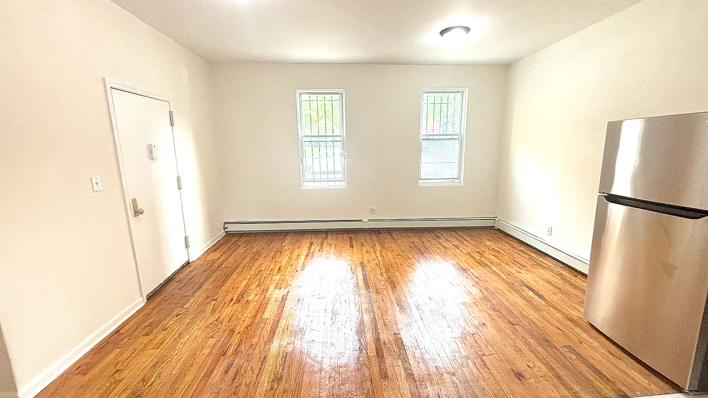918 Dekalb Avenue, Unit 1 Brooklyn, NY 11221 - Photo 2 of 11 a view of empty room with wooden floor and fan