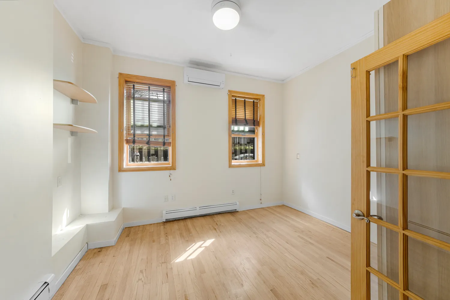 an empty room with wooden floor and windows