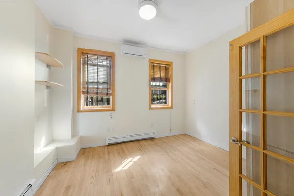 an empty room with wooden floor and windows