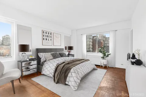 a spacious bedroom with a bed a couch and large window