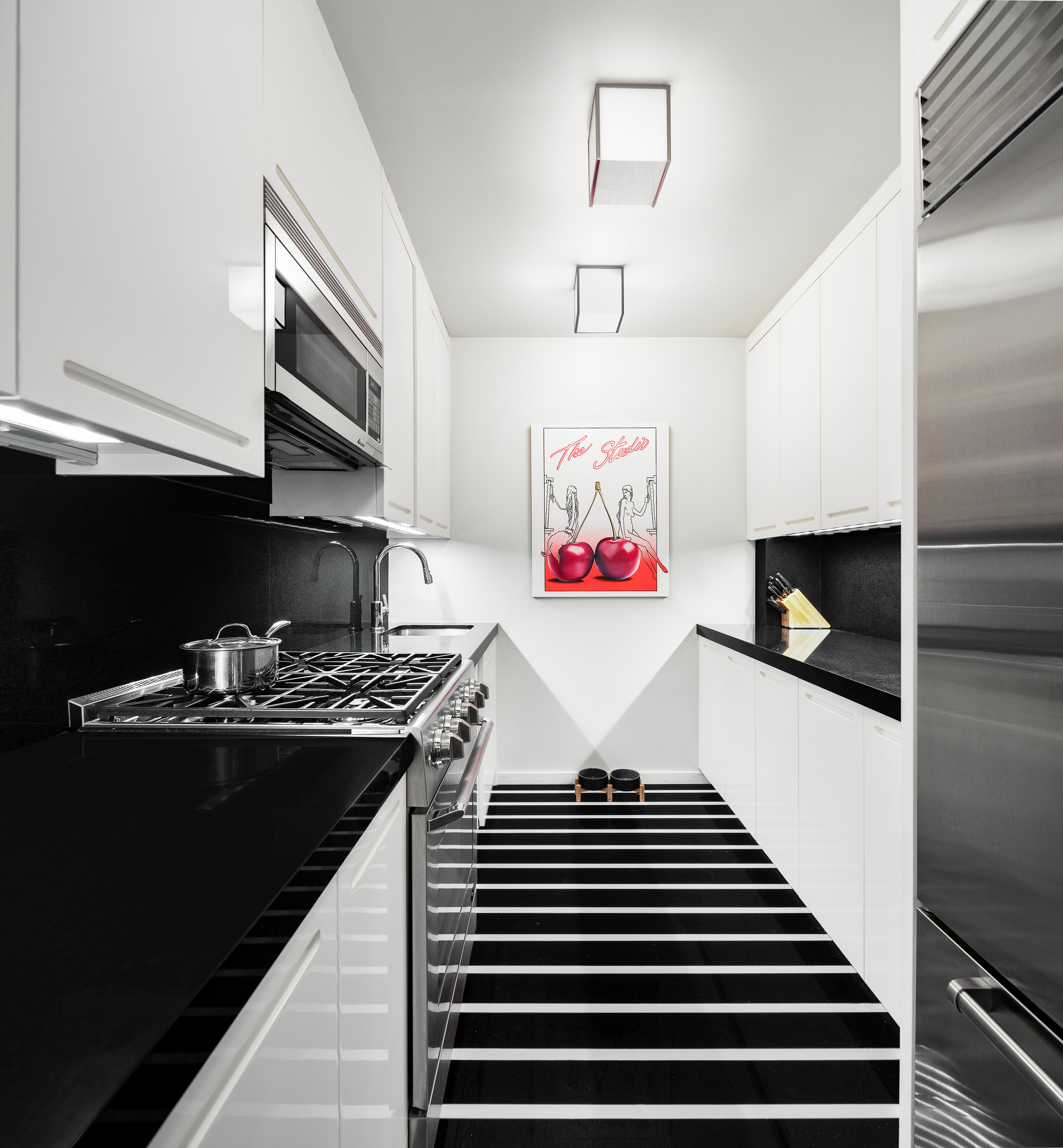 1001 5th Avenue, Unit 4C Manhattan, NY 10028 - Photo 4 of 11 a kitchen with stainless steel appliances a stove and a refrigerator