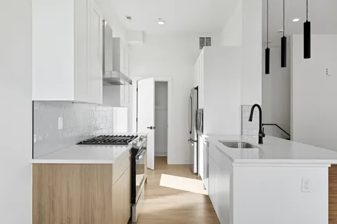 a kitchen with stainless steel appliances a white stove top oven and a sink