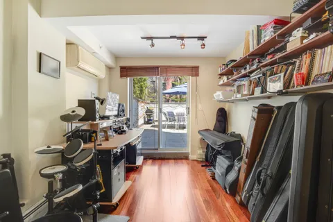 a view of a workspace with furniture and a large window