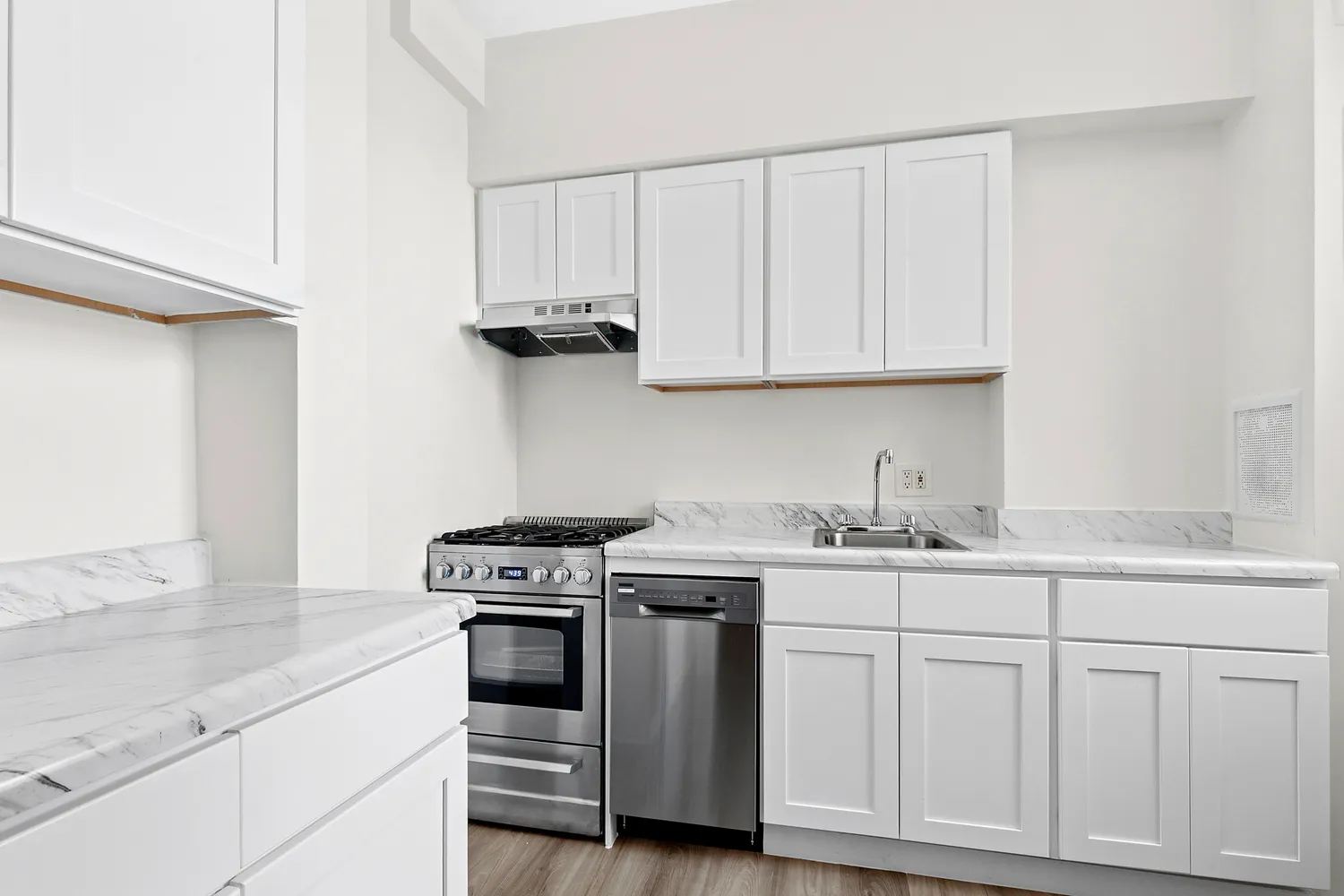 a kitchen with white cabinets and sink