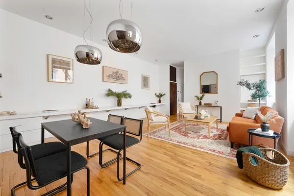 a living room with furniture kitchen view and a large window