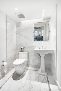 a bathroom with a sink toilet and mirror
