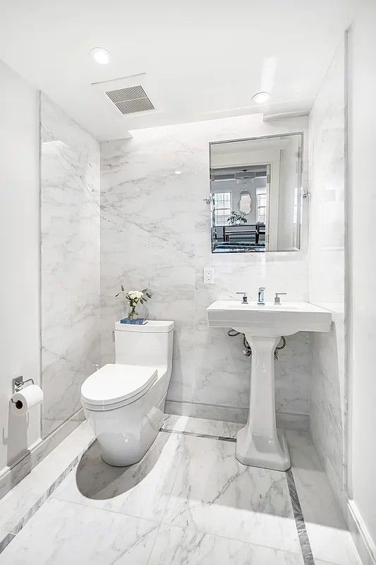 a bathroom with a sink toilet and mirror
