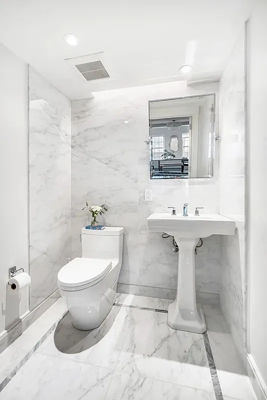 a bathroom with a sink toilet and mirror