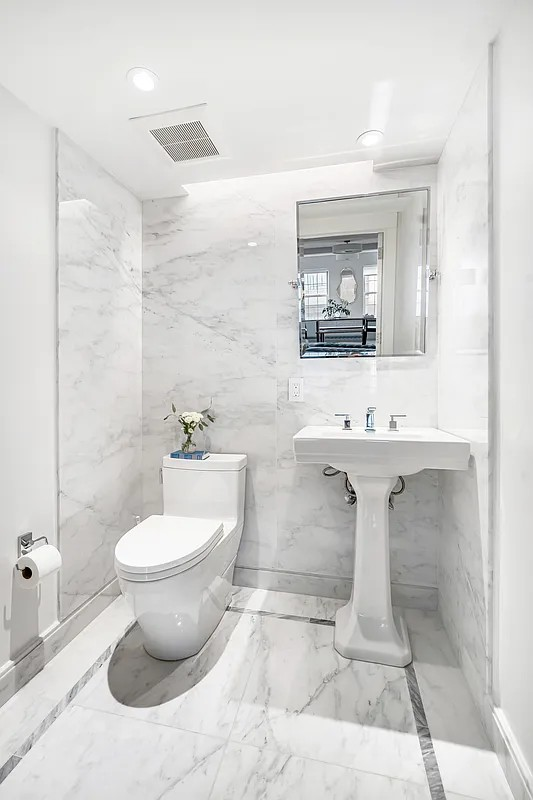 12 East 88th Street, Unit 6C Manhattan, NY 10128 - Photo 9 of 15 a bathroom with a sink toilet and mirror