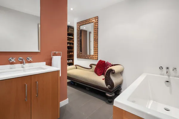 a bathroom with a tub sink and mirror