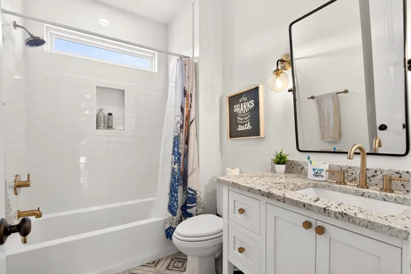 a view of a white house with a big yard and potted plants