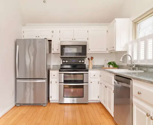 a kitchen with a refrigerator stove and wooden cabinets