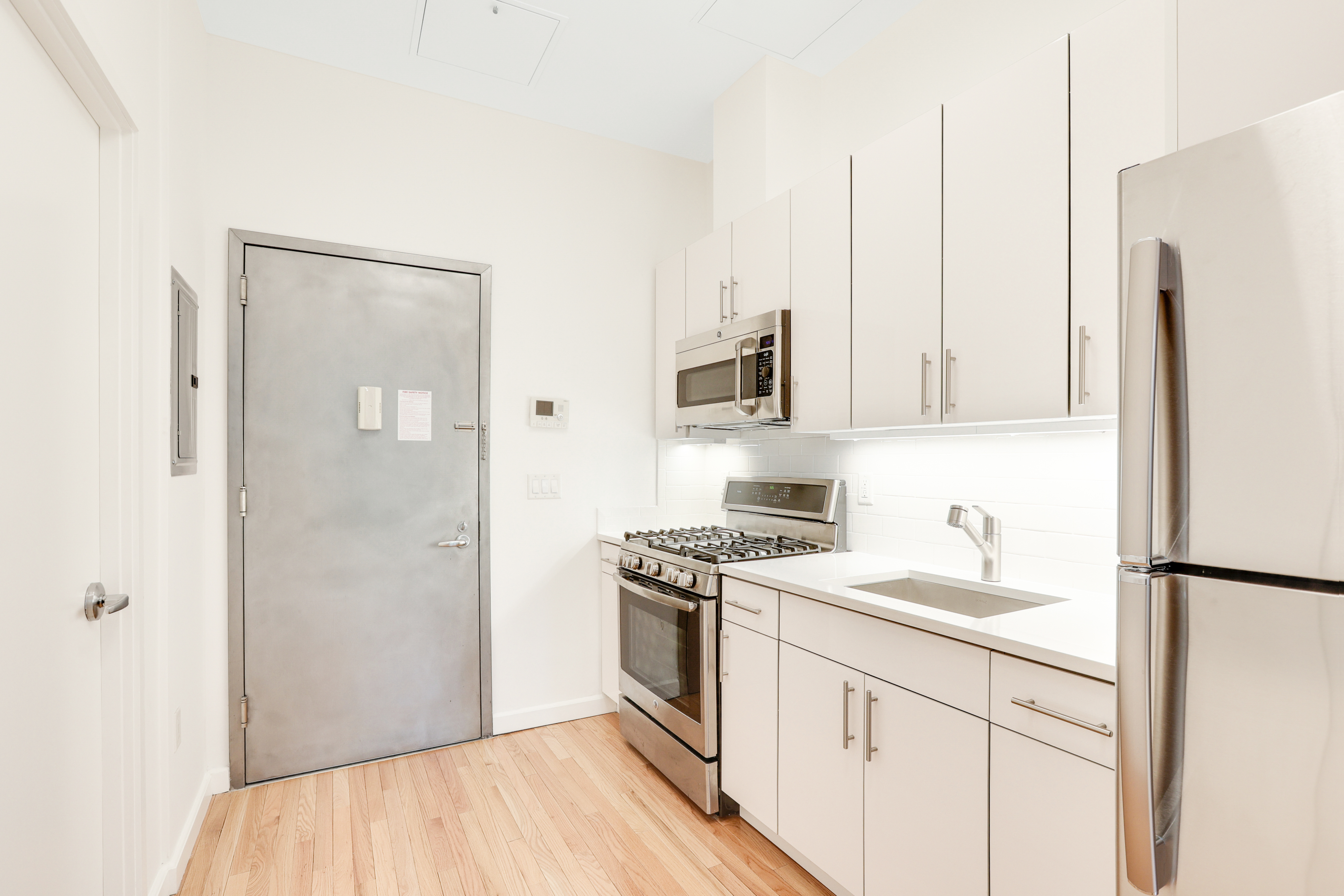 230 West 75th Street, Unit 1 Manhattan, NY 10023 - Photo 6 of 9 a kitchen with stainless steel appliances a refrigerator sink and stove