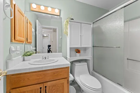 a bathroom with a sink a toilet a mirror and shower