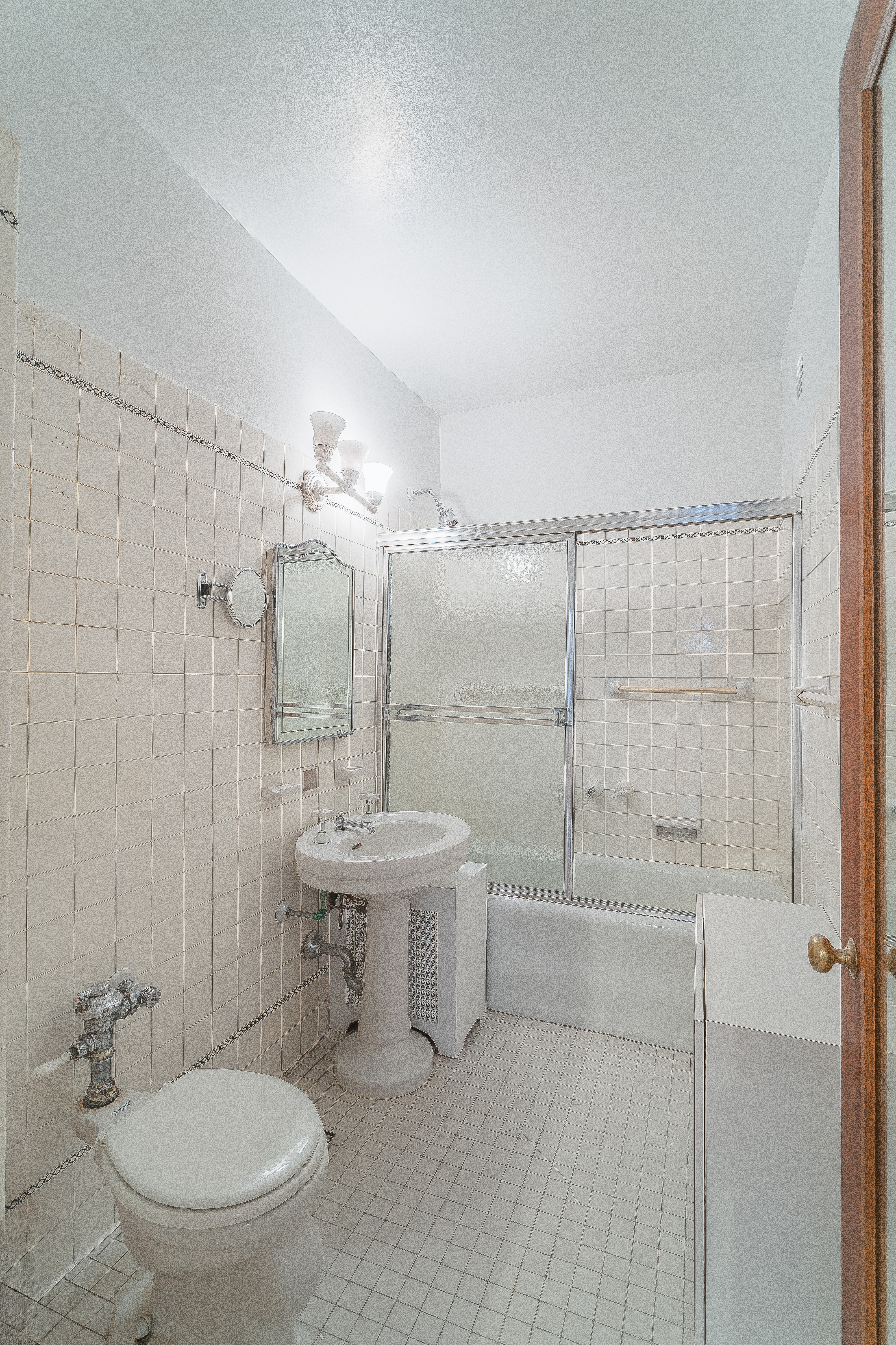 180 East 79th Street, Unit 5A Manhattan, NY 10075 - Photo 14 of 19 a bathroom with a toilet a sink and mirror