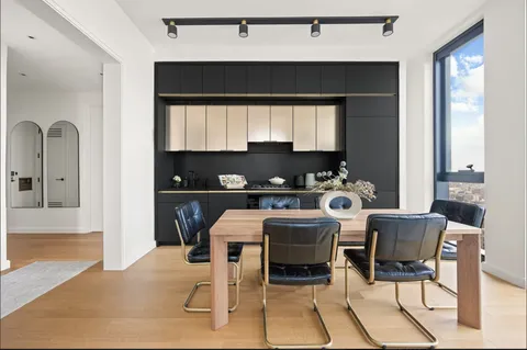a kitchen with a table chairs and a refrigerator