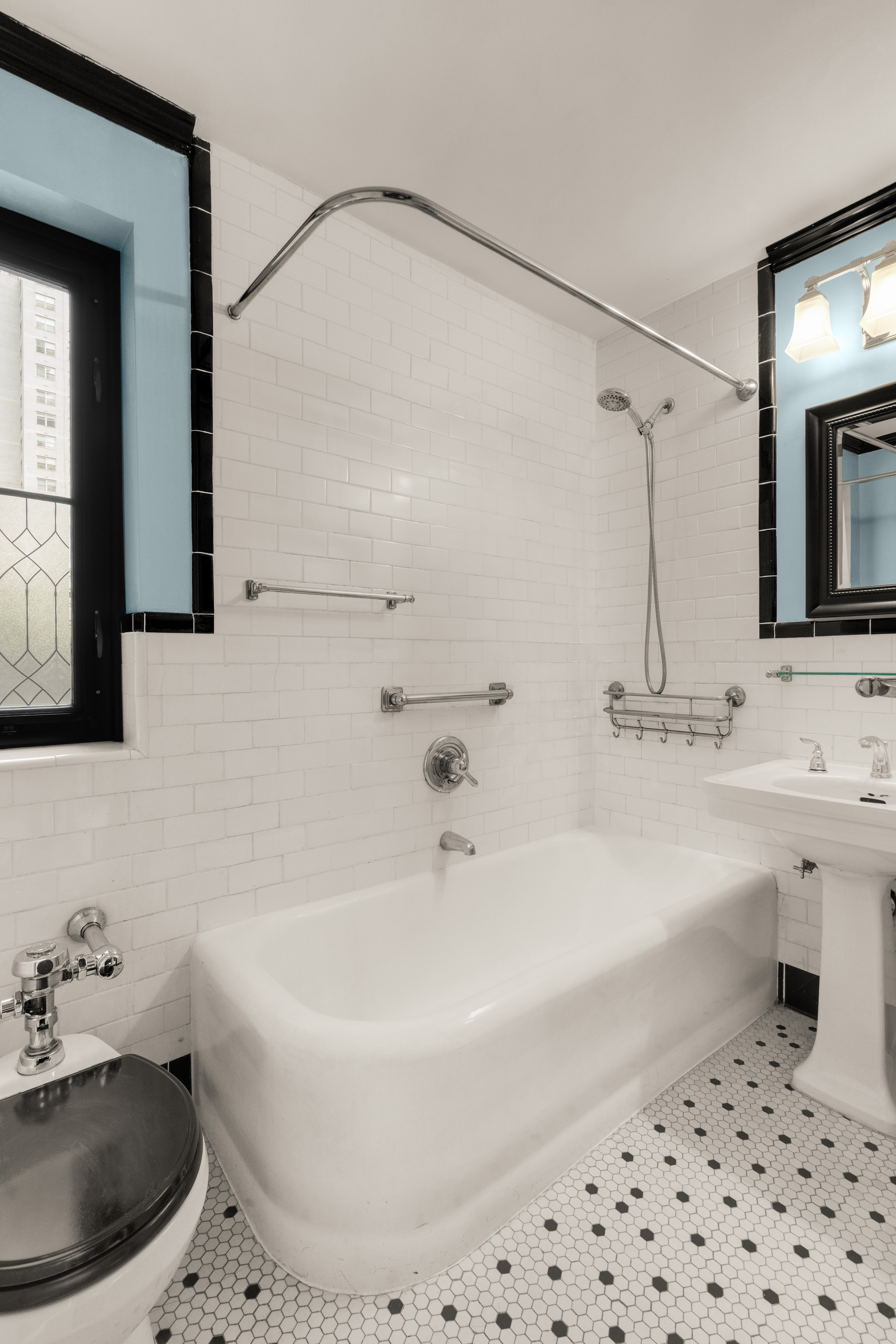 227 East 57th Street, Unit 2H Manhattan, NY 10022 - Photo 5 of 9 a bathroom with a tub sink and mirror