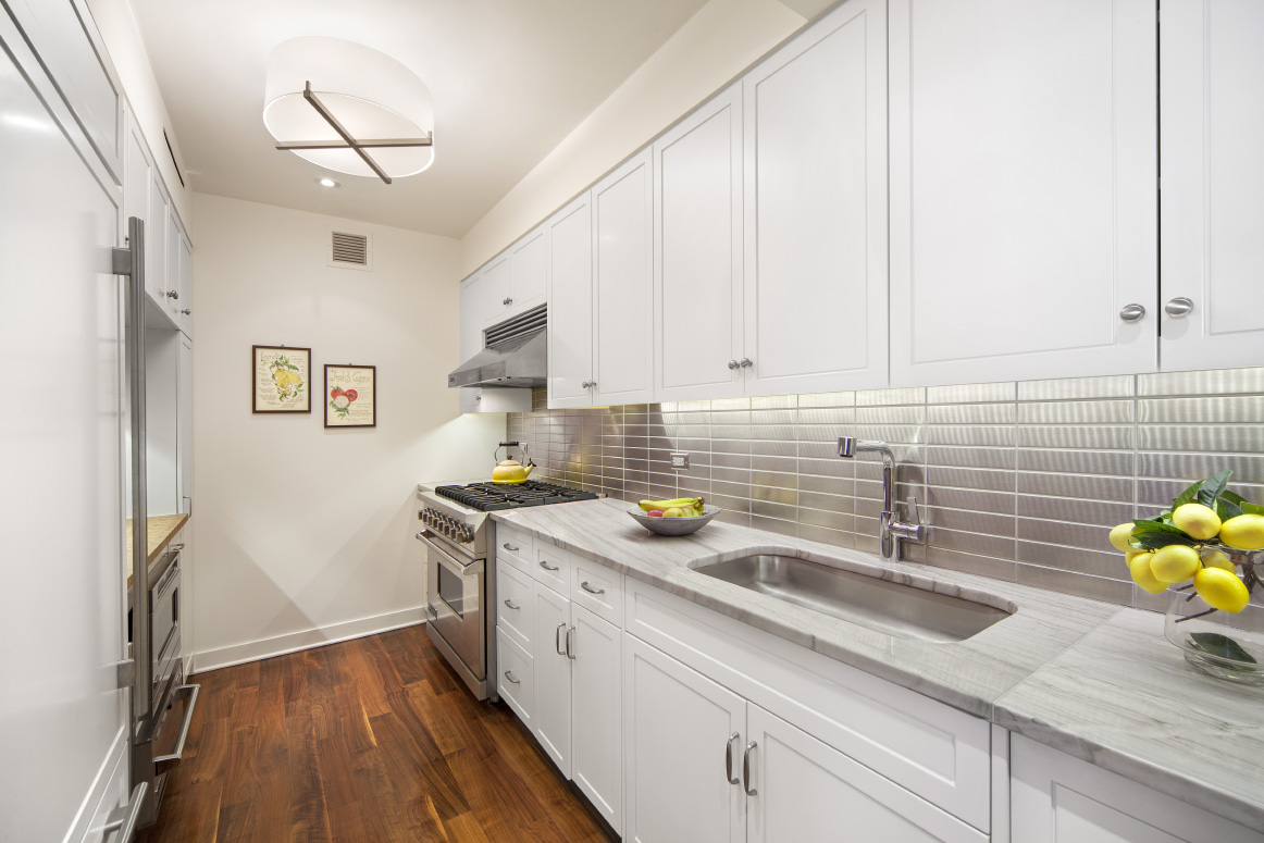 2150 Broadway, Unit 9E Manhattan, NY 10023 - Photo 5 of 14 a kitchen with stainless steel appliances granite countertop a sink a stove and wooden floors