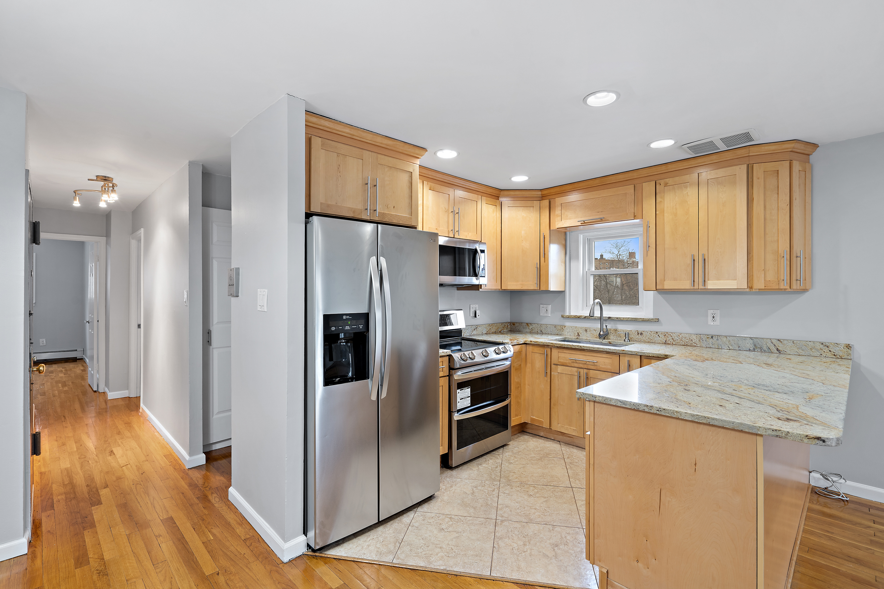 3230 Johnson Avenue, Unit 3 Bronx, NY 10463 - Photo 2 of 21 a kitchen with granite countertop a refrigerator a sink a stove and dishwasher