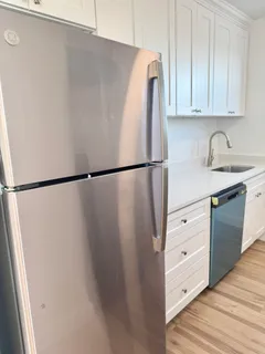 a kitchen with a white cabinet and a refrigerator