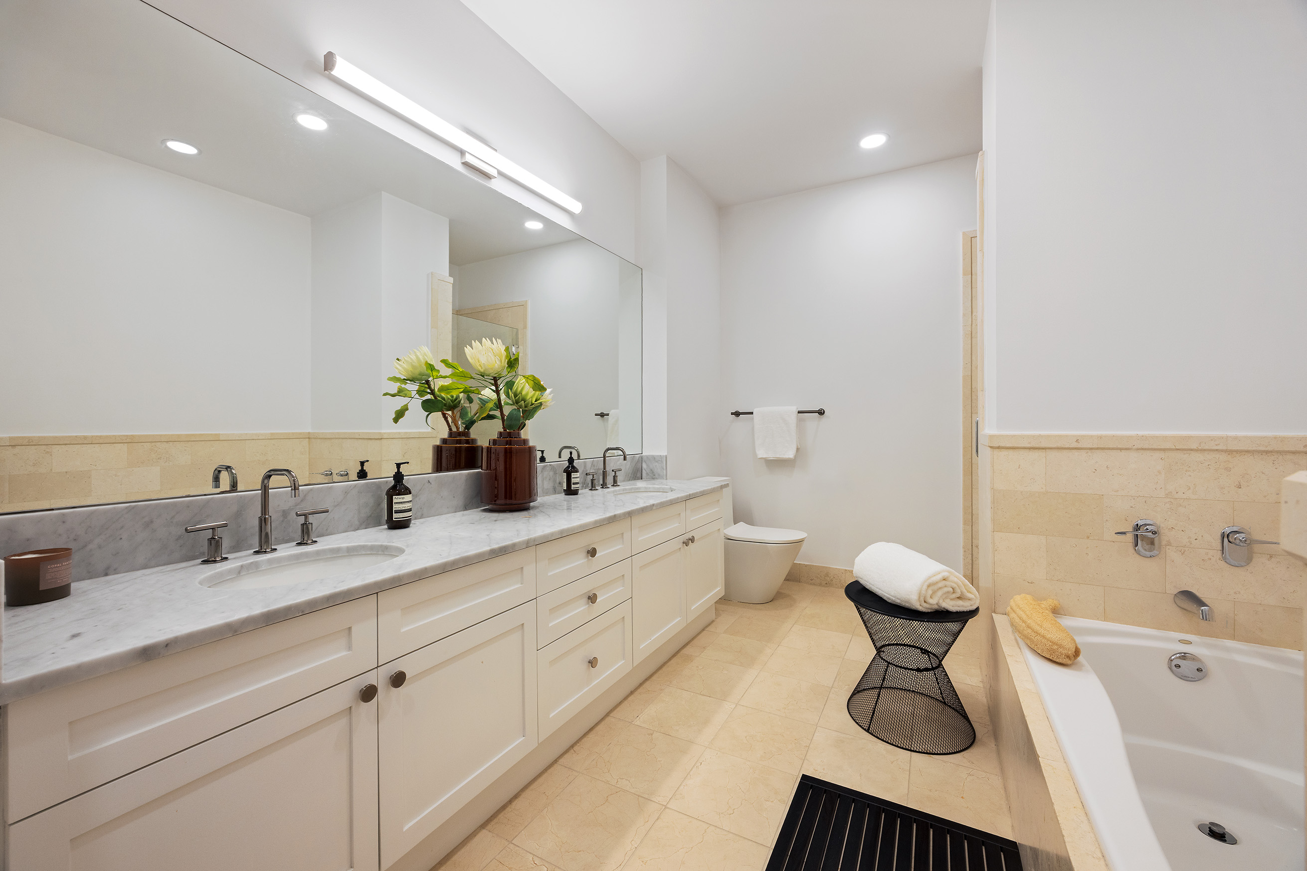 252 7th Avenue, Unit 9R Manhattan, NY 10001 - Photo 16 of 23 a spacious bathroom with a double vanity sink a mirror and a bathtub