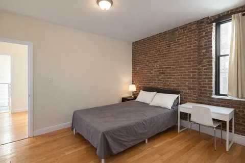 a bedroom with a bed and a window