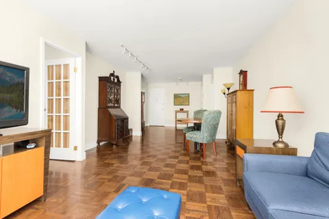 a living room with furniture a flat screen tv and a table